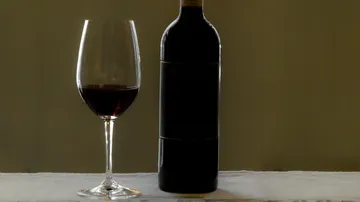 Weinflasche und Glas auf dem Tisch.
