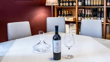 Weinflasche, Glas und Karaffe auf dem Tisch.