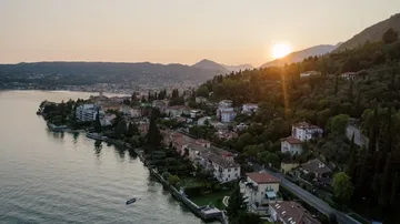 Sunset over lakeside town and hills.