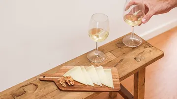 Schnittkäse und Walnüsse an Bord mit Weingläsern.