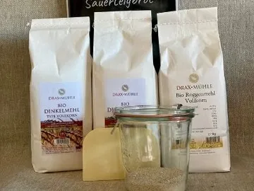 Mehlpackungen stehen neben einem Glas mit enthaltenem Inhalt.