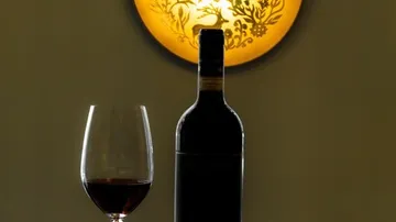 Wine bottle and glass with glowing light.