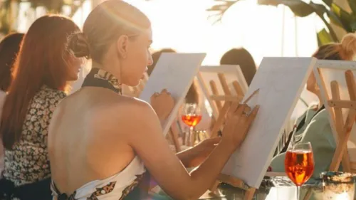 Woman painting in group at sunset.