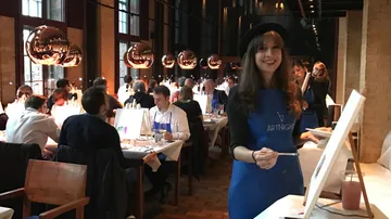 Malende Frau im geschäftigen Kunstunterricht.