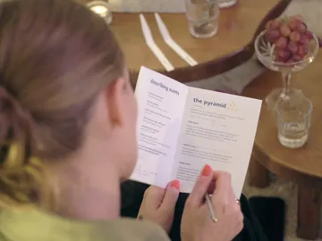 Eine Person liest in einem Heft über Duftbeschreibungen.