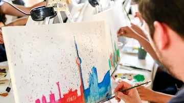 Menschen, die farbenfrohe Kunstwerke aus dem Stadtbild malen.