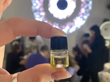 Flasche mit gelblichem Öl wird in einem Raum gehalten.