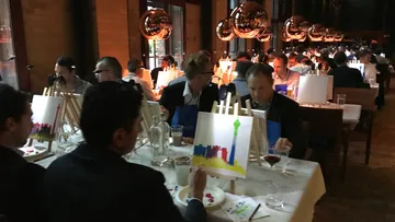 Leute, die im Restaurant auf Leinwänden malen.