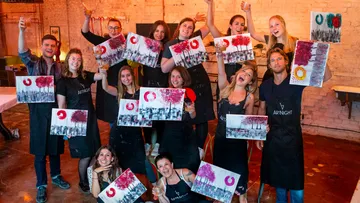 Gruppe, die Bilder hochhält, feiert, drinnen.
