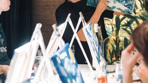 Leute, die in einem Kunstunterricht auf Leinwänden malen.