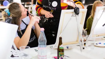 Menschen, die auf einer gesellschaftlichen Kunstveranstaltung malen.