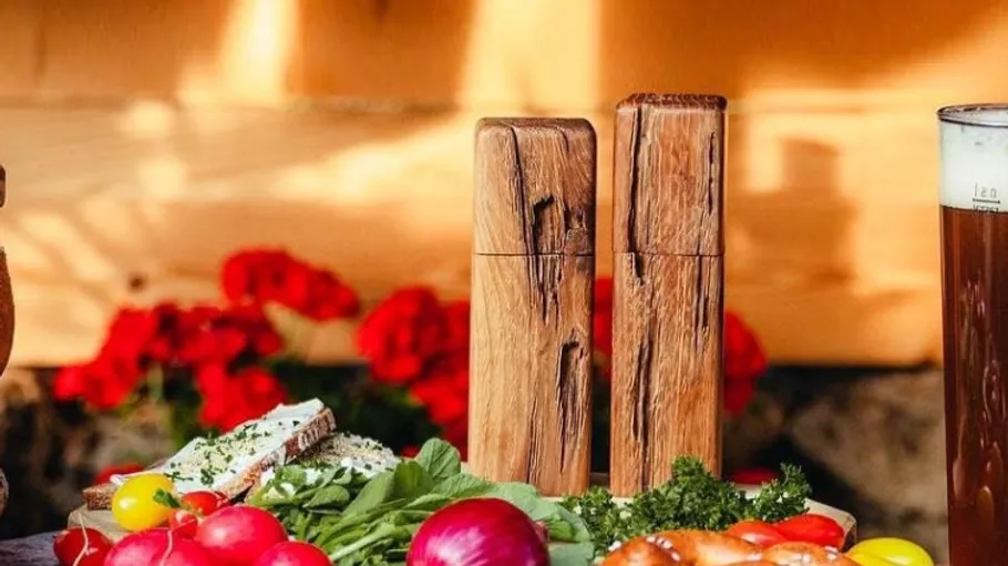 Rustic table with fresh vegetables and wooden mills.