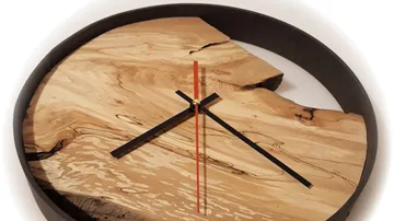 Wanduhr aus Holz und Metall mit schwarzen Zeigern.