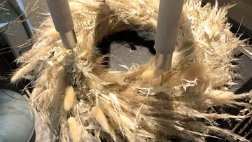 Dried grass wreath with candle holders indoors.