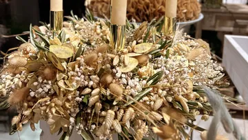Dried flower arrangement with candles in vase.