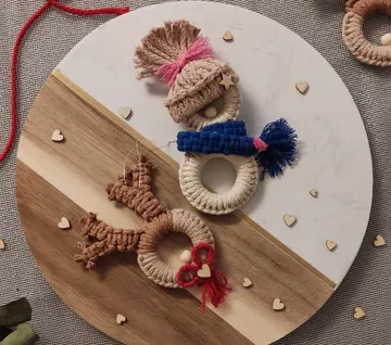Macrame reindeer and snowman on a circular board.