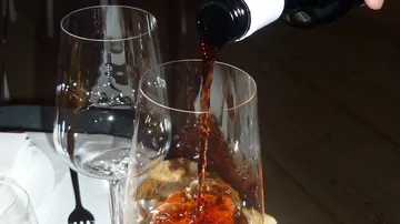 Red wine being poured into a glass.