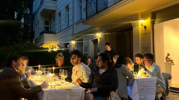 Group dining outdoors under warm lights.