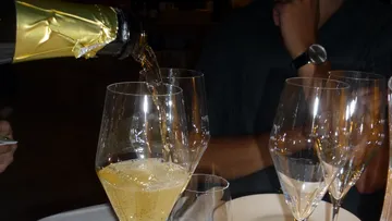 Champagne pouring into glasses at a table.