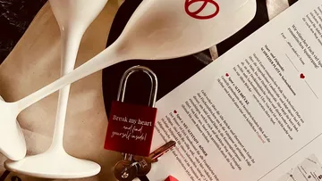 Wine glasses, lock, and menu on table.