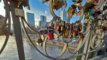 Liebesschlösser auf einer Brücke mit der Skyline der Stadt.