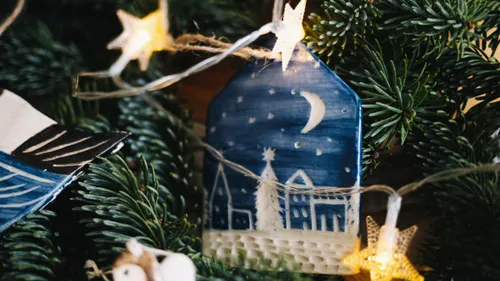 Christmas ornament on tree with star lights.