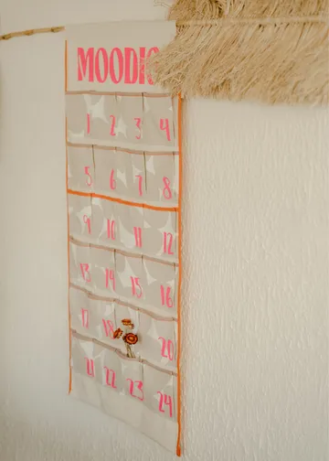 Wall calendar with numbered pockets and plant decoration.