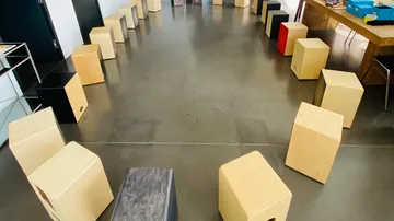Wooden cajon drums arranged in a circle indoors.