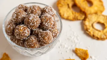 Coconut-covered energy balls in a glass bowl.