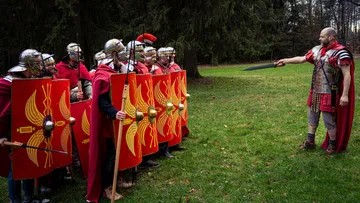 Römische Soldaten mit Schilden in Formation, Kulisse im Freien.