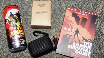 Energydrink, Paracord-Pod, Survivalguide am Boden.