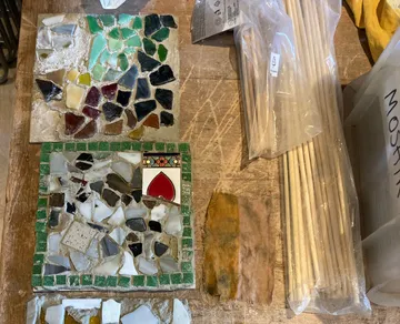 Bunte Mosaikfliesen auf Holzoberfläche.