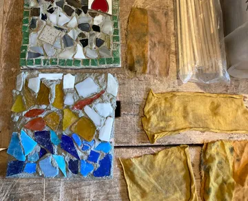 Bunte Mosaikfliesen und gelbes Tuch auf dem Tisch.