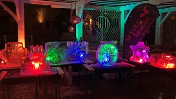 Bunte Eisskulpturen mit Neonbeleuchtung im Freien.