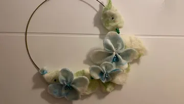 Metallrahmen mit Blumendekorationen aus Filz.