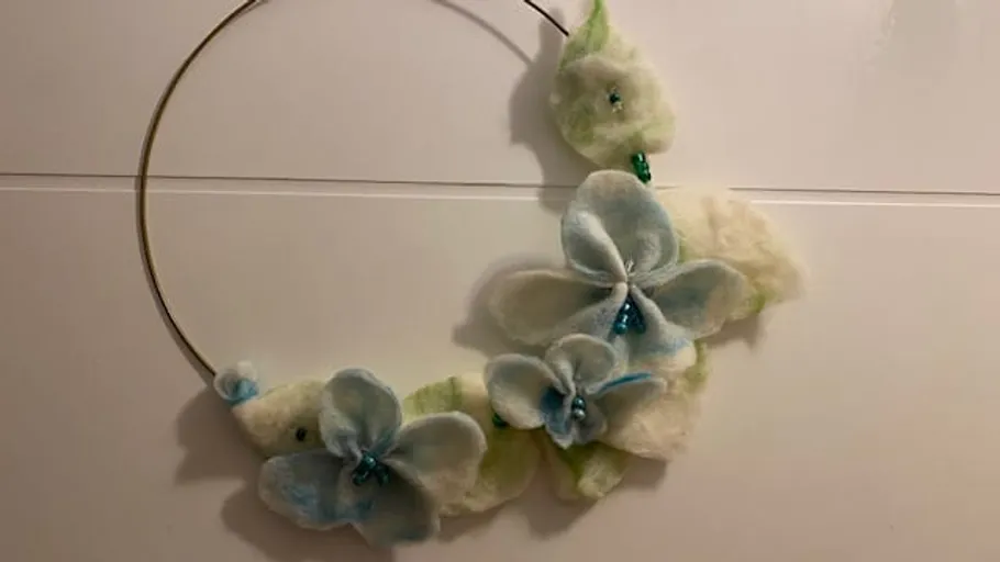 Metal hoop with felt floral decorations.