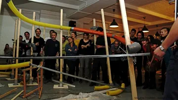 Group watching large indoor marble run.