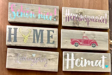 Sechs rustikale Holzschilder mit verschiedenen Motiven.