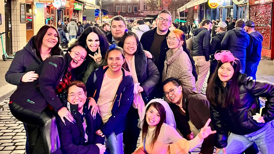 Group posing on busy nightlife street.