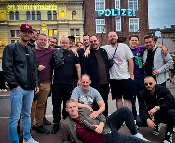 Gruppe von Männern posiert vor dem St. Pauli Theater und dem Polizeigebäude.