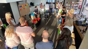 Group playing musical tubes in a room.