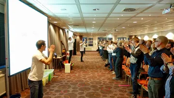 Leute klatschen in einem Konferenzraum.