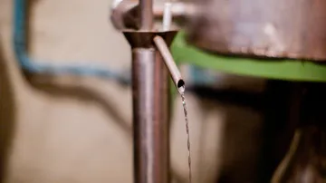 Liquid stream flowing from metal pipe.