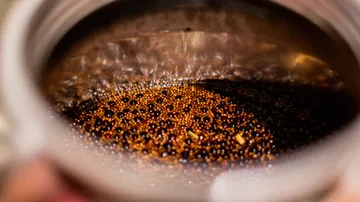 Bubbling coffee inside a metallic container.