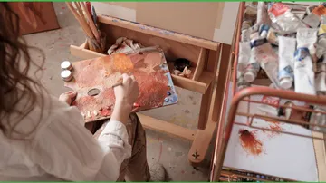 Person, die im Kunstatelier mit Palette malt.