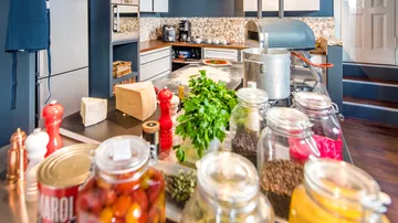 Kitchen counter with herbs, jars, and cooking pot.