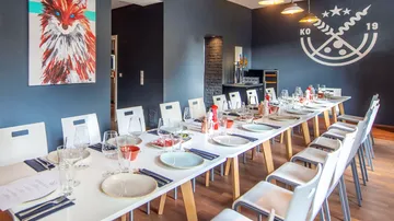 Long dining table with white chairs, colorful fox painting.