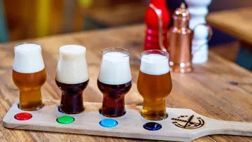 Four craft beers on tasting paddle.