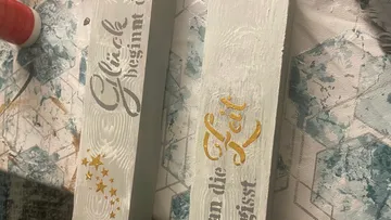 Holzbretter mit deutschem Text und Sternen.