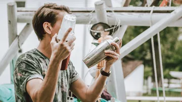 Person, die im Freien einen Cocktailshaker schüttelt